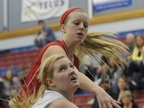 South Kamloops Titans #15 Kiersten Landrie ducks under Maple Ridge Ramblers #8 Kirby Marchand during quarter-final round action at the BC Senior Girls AAA Basketball Championship at Capilano University Sportsplex in North Vancouver on Thursday. (Les Bazso,PostMedia)