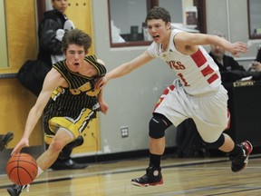 John Katerburg (left) of Kelowna is pursued by Corey Hauck of W.J. Mouat. Both teams will compete for the BC Triple A title beginning March 13. (PNG photo)