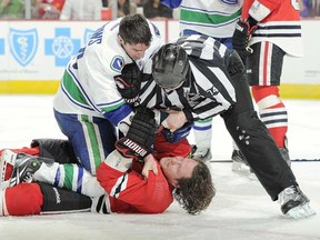 Linesman Lonnie Cameron tries to pry Alex Burrows of the Vancouver Canucks off Duncan Keith of Chicago last night in Chicago. (Bill Smith/NHL via Getty Images)