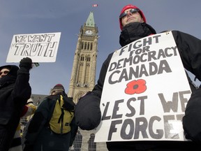 About 200 protesters called Canadians Against Electoral Fraud took to Parliament Hill on Monday to protest against the ongoing "robo-calls" issue. Here, Jason Brown from Gatineau wears a "Fight for Democracy" sign on Parliament Hill. (POSTMEDIA FILES)