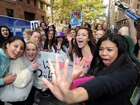 Hundreds of young female fans following the British boy band One Direction try and catch a glimpse of them during a morning television appearance in Sydney on April 11, 2012. [TORSTEN BLACKWOOD/AFP/Getty Images]