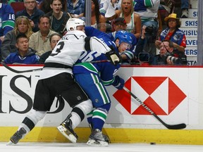 Vancouver Canucks forward Jannik Hansen fights along boards in NHL playoffs with Los Angeles Kings defenceman Willie Mitchell.