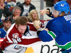 VANCOUVER, CANADA - MARCH 28: David Booth #7 of the Vancouver Canucks and Mark Olver #40 of the Colorado Avalanche trade punches during their NHL game at Rogers Arena March 28, 2012 in Vancouver, British Columbia, Canada.  (Photo by Jeff Vinnick/NHLI via Getty Images)