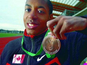 Langley Secondary's Braedon Dolfo shows the bronze medal he won when he set the Canadian record in the high jump at the 2011 Paralympic World Championships in New Zealand. (Photo -- Troy Landreville, The Langley Advance)