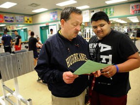 Veteran teacher-coach Robert Hallam with Rick Hansen 9th grader Pavi Gill during weight-room workout at the Abbotsford school. (Ric Ernst, PNG)