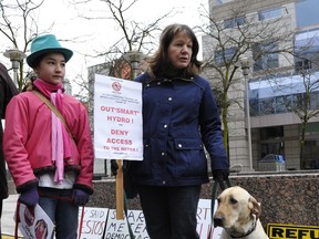 Tanesa Kiso and her daughter Quinne Kobayashi, 12, brought their dogs Zipper (L) and Jack (R) to protest smart meters outside of B.C. Hydro's Vancouver off ice on Feb. 29 (Jenelle Schneider/PNG FILES)