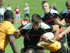 Carson Graham's Zack Smith attempts to elude Shawnigan Lake tacklers during BC Triple A rugby final Saturday in Abbotsford. (Rod Wiens, Sports Action Photography)