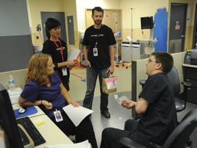 Providence Health Care HIV testing team nurse educator Nancy Chow and project assistant Rob Joynson speak to St. Paul’s Hospital emergency department nurses Sandy Alexander and Anthony Palfy about HIV testing. (Jason Payne/PNG)