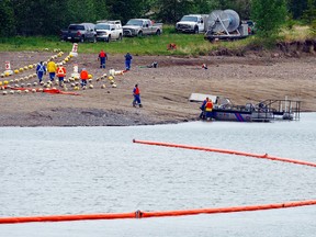 Crews prepare a boom on the Gleniffer reservoir to stop oil from a pipeline leak near Sundre, Alta., on Friday, June 8. Plains Midstream Canada says one of their non-functioning pipelines leaked between 1,000 and 3,000 barrels of oil. (CANADIAN PRESS)