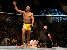 Anderson Silva is as smiles as referee Yves Lavigne tends to a beaten and battered Chael Sonnen at the conclusion of the UFC 148 main event last night in Las Vegas, Nevada.