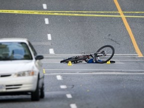 Police investigate a crash between a bicycle and a car sit on narrow, bicycle unsafe East 12th Avenue in Vancouver last August after cyclist was hit during morning rush hour. Traffic was diverted around the scene. (Ward Perrin/PNG FILES)