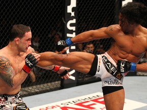 Frankie Edgar tries to catch a kick from Benson Henderson during their first encounter at UFC 144 in February.