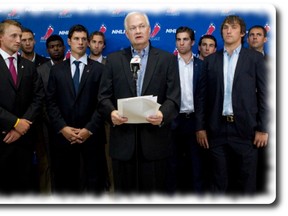 Donald Fehr (centre) Executive Director of the NHLPA stands with NHL players as they speak with the press following collective bargaining talks in Toronto on Tuesday August 14, 2012. Negotiations continue between the NHL and the NHLPA to avoid a potential lockout.THE CANADIAN PRESS/Chris Young