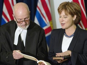 Then legislative clerk George MacMinn, now under fire for a $500,000 post-retirement contract, and Premier Christy Clark take part in her swearing in as the MLA for Vancouver-Point Grey on May  30, 2011. (TIMES COLONIST FILES)