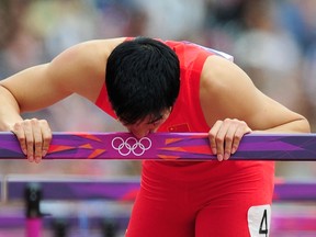 China's Liu Xiang hopped down the track after crashing into the first hurdle in the men's 110m heat at the London Olympics. At the final hurdle, he bent over and kissed it, perhaps signifying the end of his great career. Getty Images photo.