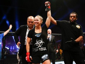 Ronda Rousey is all smiles as referee Herb Dean raises her arm in victory following her win over Sarah Kaufman last night in San Diego. (photo courtesy of Strikeforce)