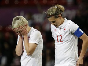 Canadians Sophie Schmidt (left) and Christine Sinclair were more than disappointed after a late soccer loss to the U.S. Monday. AP Photo.