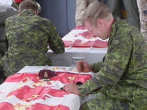 Distraught Canadian soldier bangs his fist on the coffin of one of his buddies killed in the 2002 friendly fire incident in Afghanistan that traumatized  wounded warrior Yan Joseph Marcel Berube, now accused of a minor weapons incident that could send him to jail for three years. (PNG FILES)