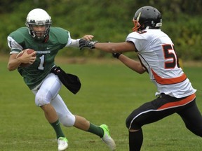 Lord Tweedsmuir quarterback Connor McKay (left) attempts to elude New West's Tiger Xu during Triple A football contest Friday in Cloverdale. (Les Bazso, PNG)