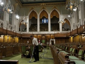 Well, that’s one way to clean up Parliament. Maintenance staff member Andre Dube vacuums the carpet in the House of Commons on Friday. (CANADIAN PRESS FILES)