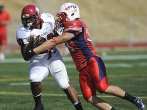 Central Washington's Demetrius Sumler (left) tries to break free from SFU's Dylan Roper on Saturday at Terry Fox Field, (Jason Payne, PNG)