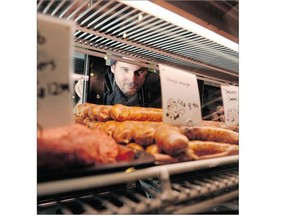 Andy Sedlak, head butcher at Big Lou's Butcher Shop, slides sausages into the case at the old-world butcher shop in Vancouver. Photograph by: Gerry Kahrmann, PNG, The Province