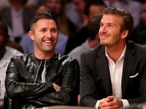 Robbie Keane and David Beckham watch the L.A. Lakers season opener. Becks is a big fan of Victoria's Steve Nash. (Stephen Dunn/Getty Images)