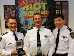 Insp. Laurence Rankin, riot team commander Les Yeo and Vancouver police Chief Jim Chu, left to right, display the international award they received for the department's investigation into the Stanley Cup riot.(Jenelle Schneider/PNG FILES)
