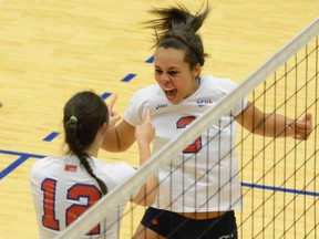 Simon Fraser left side Jessica Young (right) shows her emotion Wednesday in the Westy Gym as she celebrates a point with teammate Rachel Vanstone. The Clan swept visiting Capilano 3-0 in non-conference play.