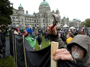 Protesters put up a massive banner during a sit-in at the legislature in Victoria on Monday to protest against proposed pipelines. Many Province readers say the protesters owe their comfortable lives to previous pipelines and other forms of economic progress. (CANADIAN PRESS FILES)