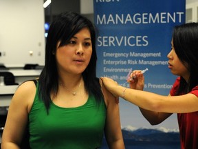 Yvonne Huang, a student from the faculty of pharmacuetical sciences, gives a shot to lecturer Kathy Seto during a flu clinic for staff and students at UBC on Oct. 30. (Jenelle Schneider/PNG FILES)