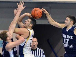 Kitsilano's Luka Zaharijevic (white) has his shot attempt thwarted from behind by WRCA's Vartan Tanielian during Telus Basketball Classic final Saturday at UBC. (Wilson Wong, UBC athletics)