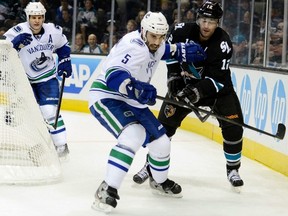 Canucks defenceman Jason Garrison (5) battles with Sharks forward
 Patrick Marleau (12) in San Jose on Sunday.  (Photo by Thearon W. Henderson/Getty Images)