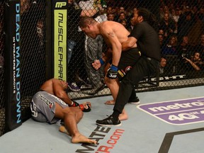 Herb Dean holds back Antonio Silva as he shouts at a fallen Alistair Overeem at UFC 156.