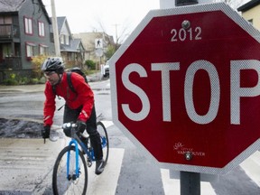 Cyclist passes a stop sign on the bike route at Hawks Avenue in Vancouver. A bike group says riders should be allowed to yield at stop signs. (Ian Lindsay/PNG FILES)