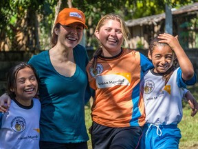 Erin Karpluk (in ball cap) and a World Vision staffer, with soccer players
