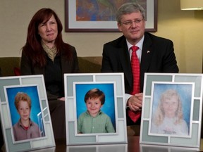 Stacy Galt, cousin of Darcie Clarke, whose three children were killed by their deranged father, Allan Schoenborn, in 2008, sits with Prime Minister Stephen Harper as he announced tougher laws for mentally ill offenders. (THE CANADIAN PRESS FILES)