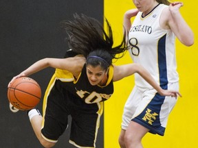 Burnaby South's Pav Brar struggles to hold her balance as she attempts to dribble away from Kitsilano's Lauren Palmer during Friday action at the Crehan Cup Lower Mainland senior girls Triple A basketball championships at South. The host school won 58-51. (Gerry Kahrmann, PNG)