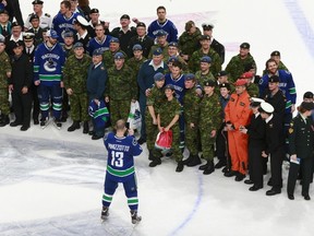 Vancouver Canucks' Steve Pinizzotto snaps photos of the Canadian military and his teammates March 14, 2013 at Rogers Arena.