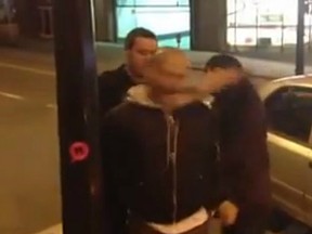 Slightly blurry screen grab from a video shows Vancouver police officer Ismail Bhabba punching cyclist Andishae Akhaven during his arrest. (Mike Schwarz/PNG FILES)