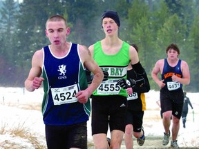With only a sock covering his numb left foot, Ben Weir of Glenlyon Norfolk School, chased by Oak Bay’s Liam Kennell, speeds through the snow-covered course in Prince George on Nov. 3 at the B.C. High School Cross Country Championships. Weir runs in the 3,000 and 1,500 metres at the B.C. High School Track and Field Championships later this month in Langley. (Photo – David Mah, The Prince George Citizen)