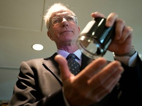 Newspaper publisher David Black holds a jar of raw bitumen as he speaks about his proposal to build a refinery in Kitimat to refine oil from the proposed Enbridge Northern Gateway Pipeline, during a news conference in Vancouver last August. (THE CANADIAN PRESS FILES)