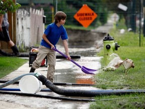 Daniel Boddy, nine, is one of thousands of Calgary residents pitching in to help with cleanup after the flood that forced a mass evacuation. (THE CANADIAN PRESS)
