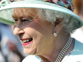 Queen Elizabeth attends a garden party at Buckingham Palace in London on Thursday. Her 91-year-old husband, Prince Philip, was admitted to hospital for "exploratory" surgery and is likely to stay there for two weeks. (AFP)