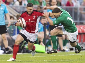 Team Canada wing James Pritchard, left, breaks a tackle against Team Ireland wing Fergus McFadden, right, during first half of an international friendly rugby match in Toronto on Saturday, June 15, 2013. THE CANADIAN PRESS/Nathan Denette