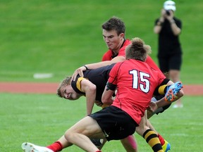 Shawnigan Lake Stags Tyler Beselt gets taken down by St. George's Theo Sauder (15) and Karsten Leitner in Triple A BC final Saturday in Abbotsford. (John Van Putten, The Abbotsford Times)