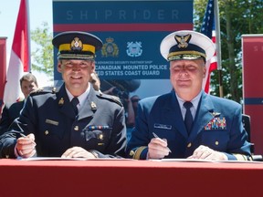 RCMP Deputy Commisioner Craig Callens, left, and Rear Admiral Keith Taylor of the U.S. Coast Guard pose Monday prior to signing the Shiprider Agreement during a press conference at Peace Arch Park. (Richard Lam/PNG FILES)