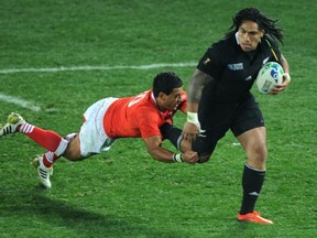 New Zealand All Blacks center Ma'a Nonu escapes with the ball in front of Tonga's fly-half Kurt Morath (L) during the 2011 Rugby World Cup pool A match between New Zealand and Tonga at the Eden Park stadium in Auckland on September 9, 2011.    AFP PHOTO / GABRIEL BOUYS (Photo credit should read GABRIEL BOUYS/AFP/Getty Images)