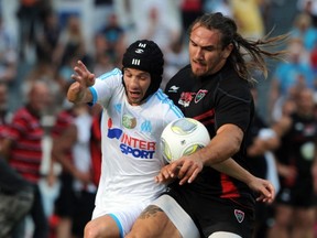 Marseille's French midfielder Mathieu Valbuena (L) vies with RCToulon's flanker Pierrick Gunther during the French friendly semi-rugby, semi-football match Rugby Club Toulon vs Olympique de Marseille at the Mayol stadium on July 17, 2013 in Toulon, southern France. ANNE-CHRISTINE POUJOULAT/AFP/Getty Images