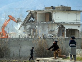 In this photograph taken on Feb. 26, 2012, young Pakistani children play near demolition works on the compound where Al-Qaeda chief Osama bin Laden was slain in the northwestern town of Abbottabad. Collective failures, incompetence and negligence by Pakistan allowed bin Laden to live in the country undetected for more than nine years, a leaked report, published on July 8, 2013, says. (AFP PHOTO)